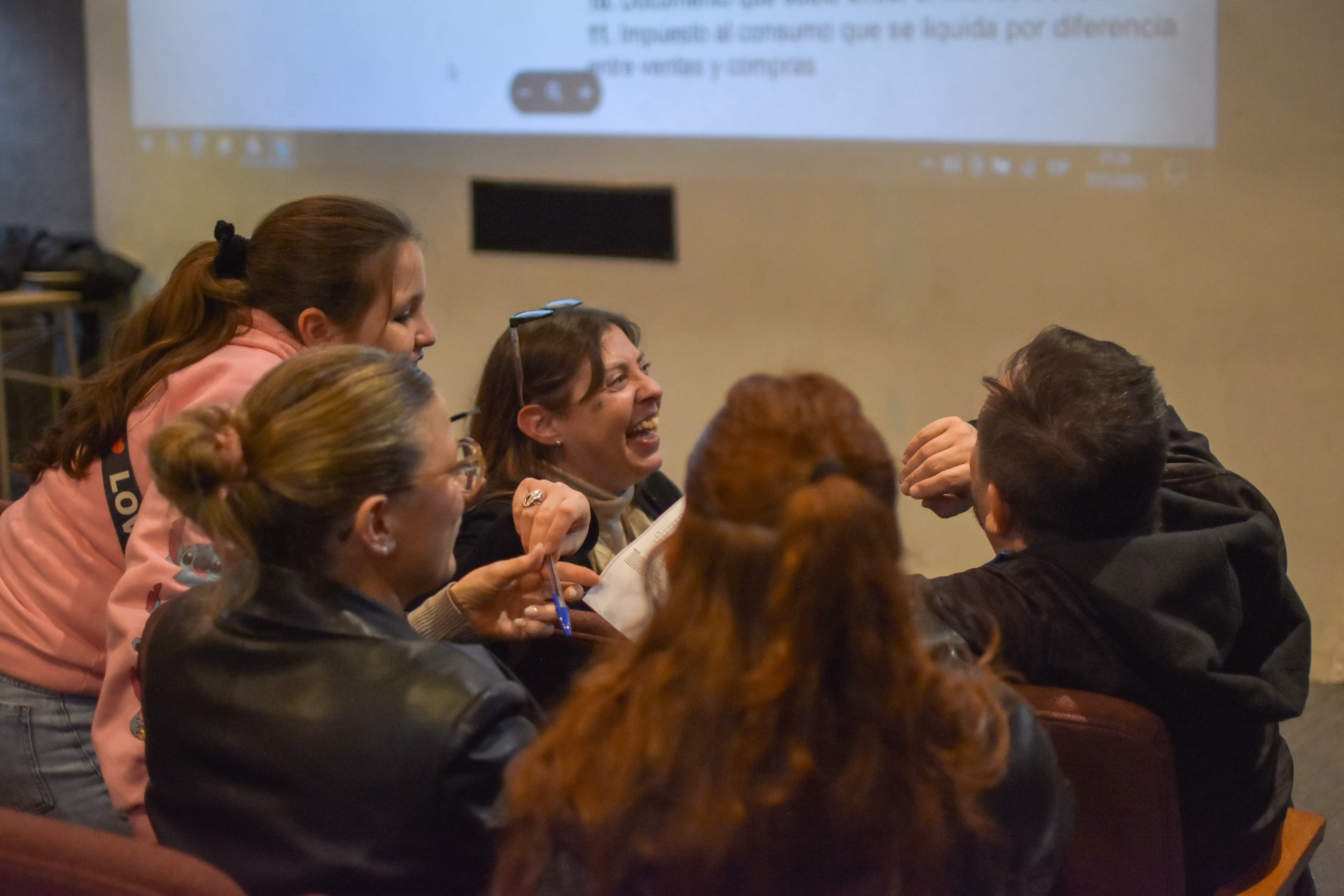 Familia resolviendo un crucigrama sobre conceptos de economía en la sala de cine